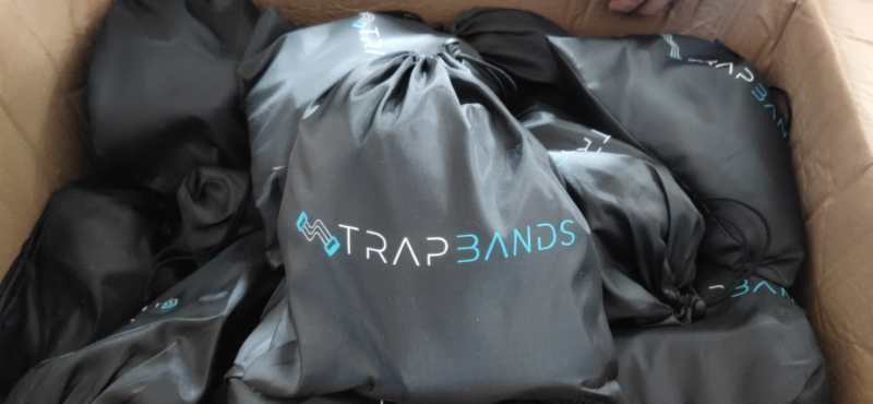 Box filled with black TrapBands drawstring bags for Fitness Rally workout equipment.