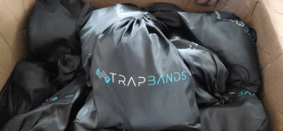 Box filled with black TrapBands drawstring bags for Fitness Rally workout equipment.