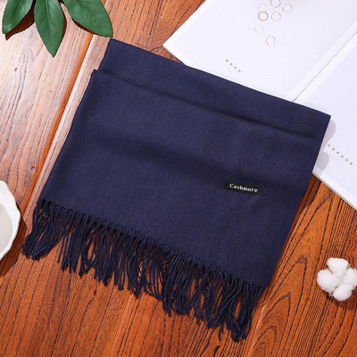Navy blue cashmere women scarf shawl with fringes on wooden surface