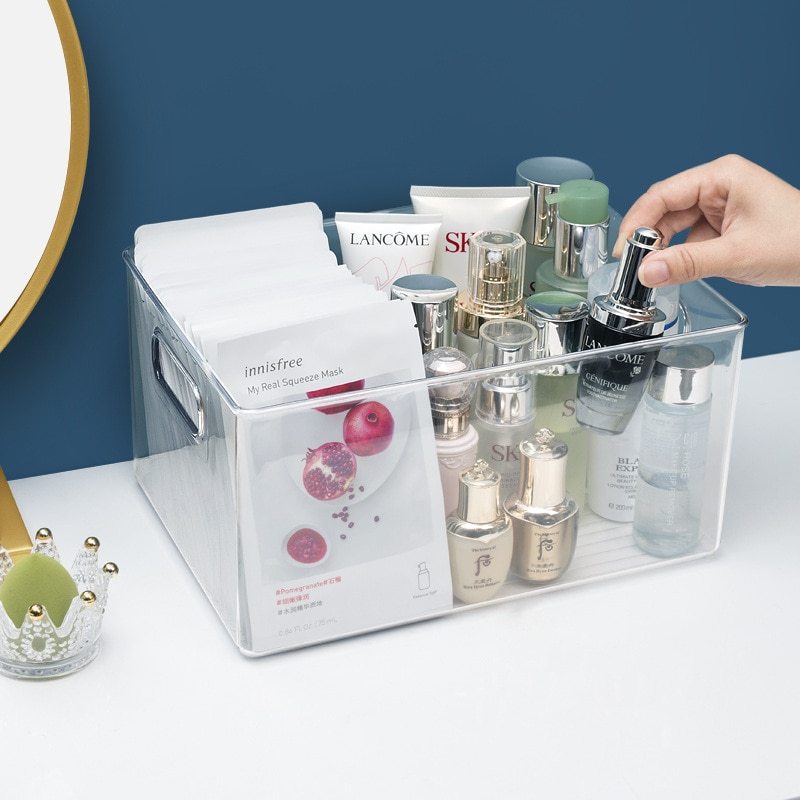Clear plastic skin care product storage box organizer with multiple cosmetic bottles and face masks inside