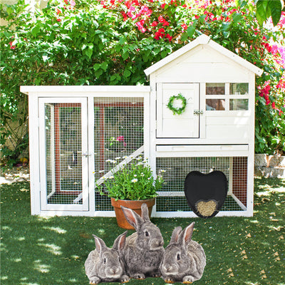 Heart-shaped black pet food bag made of 600D Oxford cloth for small pets, shown with rabbits near a white wooden hutch outdoors