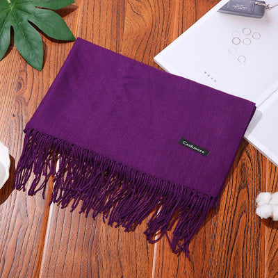 Purple cashmere women scarf shawl with fringed ends on wooden table