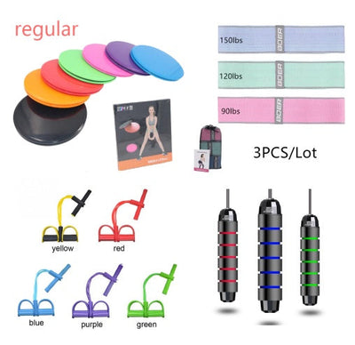 Set of colorful fitness equipment including resistance bands, sliders, jump ropes, and pedal exercisers for home workouts and body fitness