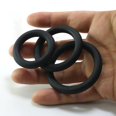 Black silicone rings in various sizes held in hand